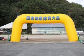 「田老地区体育大会」と書かれた黄色のエアーアーチが田老第一中学校校庭に設置されている写真