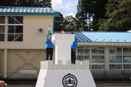 白い炬火台に火を灯す参加者の写真