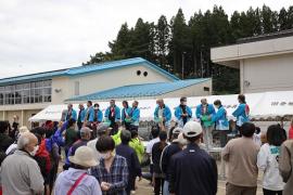 青い法被姿の関係者が参加者の前に並んでいる写真