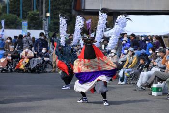 色鮮やかな衣装を着た人々が会場で踊りを披露している写真