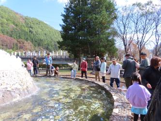 まつりの参加者たちが浅い水場で釣りをしている写真