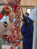 ひなまつりでつるしびなを飾り付ける様子の写真