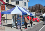 鍬ケ崎元気市で開かれた、震災前の鍬ケ崎の街並み写真展のテントで来場者が写真を眺めている様子の写真