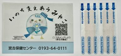 啓発キャラクターうみねこのみゃーさんのイラストが描かれた連絡先のカードと絆創膏の写真