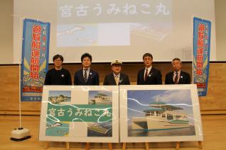 遊覧船運航開始という文字のついたのぼり旗を両脇に置いて、宮古うみねこ丸の船の名前を発表する男性達を正面から写した写真