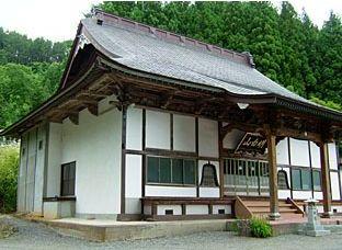 背景に多くの木が生い茂っている久昌寺を斜めから撮影した写真