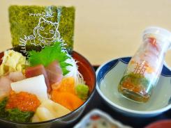 多くの種類の刺身が盛り合わせてある海鮮丼と瓶詰めされている商品を撮影した写真