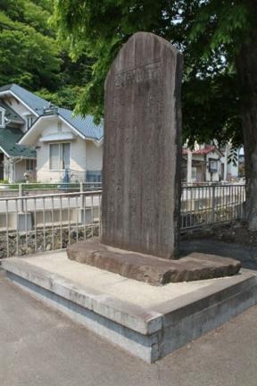 石碑の淵に津波の到達位置と思われる線が刻まれている石碑を右横から写した写真
