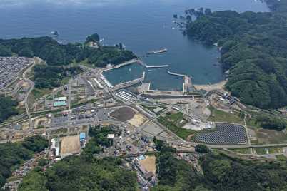 山に囲まれた海沿いの沿岸部に広がる田老漁港を上空から写した写真
