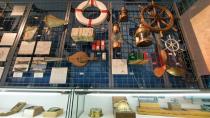 壁一面に歴史を感じさせる船の部品、作業道具が展示されている様子の写真