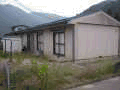 一戸建て住宅が隣り合わせで並んでいる平屋建て長屋住宅を庭側から撮影した写真