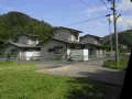 緑に囲まれ、2階建て刈屋日向団地住宅が4棟並んだ写真