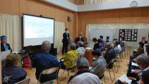 鍬ヶ崎公民館内にパイプ椅子を並べ市民説明会が行われている写真