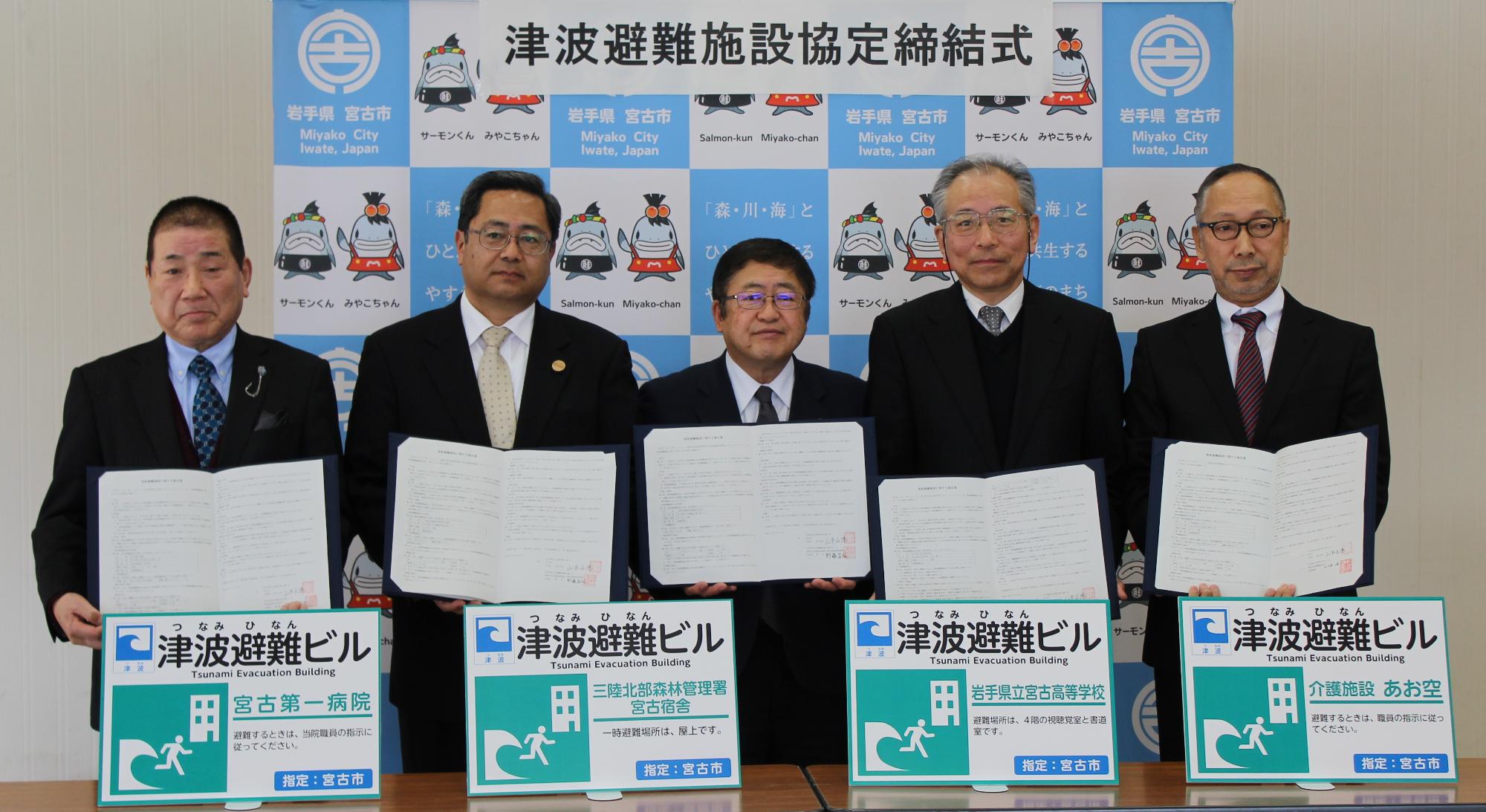 津波避難施設協定締結式で5名の関係者の人たちが協定書を持ちながら記念撮影をしている写真