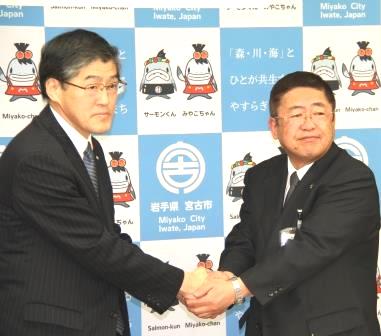 山本正徳宮古市長と宮古カントリークラブ八重樫義一郎代表取締役が両手で握手をしながら記念撮影をしている写真