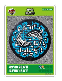 二匹のサケが円を描くように書かれているマンホールの写真