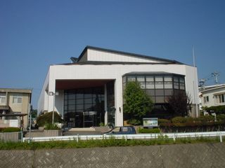 入り口横は、沢山の植木が植えられ、大きなガラス張りで作られた、ホワイト色の宮古市立図書館の写真