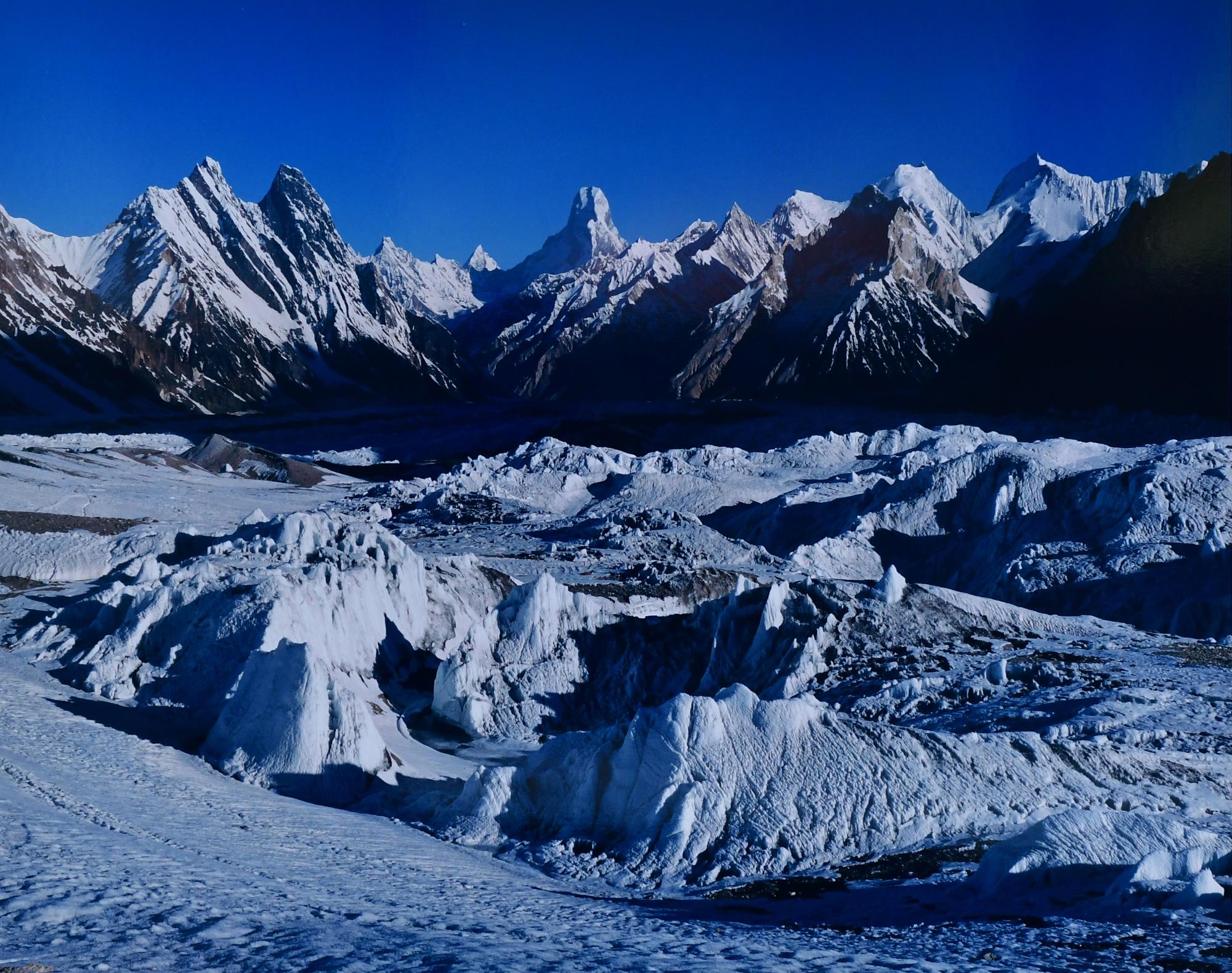 青空をバックに、塔のような形状の氷雪の山がいくつも連なっている風景を撮影した写真