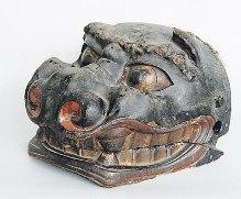全体的に黒色で鼻と口が赤く、歯をむき出しにした獅子に似ている顔だけの権現様(獅子頭)の写真