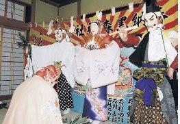 正座をし頭を下げている人の前で、色鮮やかな着物や羽織袴を着用した能面を付けた三人が、扇子などを手に持ち岩戸開きを行っている写真