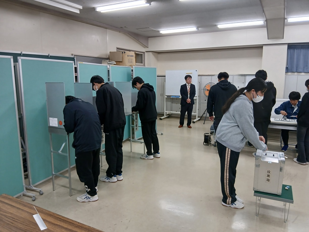 選挙人を記載台に案内する高校生スタッフ