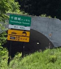 「千徳城トンネル」と書かれた看板が設置されたトンネル入り口を見上げるように撮影した写真