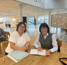 創業スクールの方と中村さんが椅子に座り記念撮影をしている写真