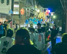 船山車の上で演奏をしている参加者と周りを半被を着た参加者と来場者で溢れているパレードの様子の写真