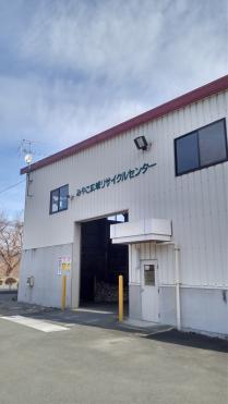 中央の左右に黄色のポールが立っている大きな入り口が設けられ、白色の外壁の上に「みやこ広域リサイクルセンター」と書かれた建物外観の写真