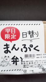お腹いっぱいになったクマのイラストと、平日限定日替わりまんぷく弁当と大きく書かれた豚生姜焼きのっけ弁当のパッケージをアップで撮影した写真