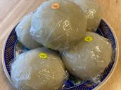 花柄の青色の丸皿にラップでくるんだ5つの饅頭が置かれた写真