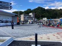 屋外広場に設置された椅子に観客が座り、ステージトラックに立つミュージシャンの演奏を聞いている「みやこまち音楽祭」の様子の写真