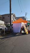 敷地内や細い道路沿いにタープテントが設置されたマルシェ会場の写真