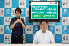 右に市長が座り隣に紺色の作業着姿の女性が手話をしている写真(新型コロナウイルス感染者等へのご配慮をお願いします~宮古市長メッセージ~YouTubeのサイトへリンク)