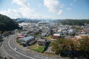 青空の下、緑の豊富な山に囲まれた宮古市市街地の写真