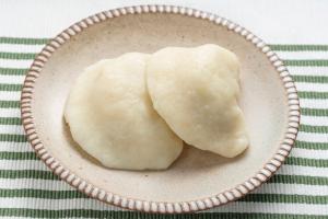 白に緑のラインの入ったテーブルクロスの上の皿に、餃子のような二つの「ひゅうず」がのせてある写真