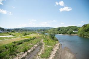緑豊かな場所にがれる真閉伊川(へいがわ)から早池峰山(はやちねさん)方面を写した写真