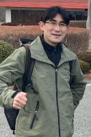 屋外で笑う男性を正面から写した写真