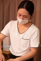 白いマスクをしながらエステの施術をしている様子の女性の写真