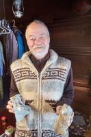 暖かそうな服装をして両手に物を持っている男性を正面から写した写真