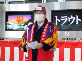 カラフルな法被姿の市長がマイクスタンドの前に立ち、挨拶をする写真