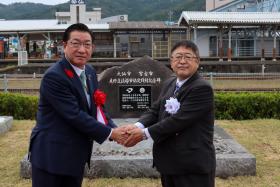 記念碑の前で、市長と老松大仙市長が握手をしている写真