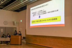 スクリーンに映された資料を元に、話をする高校生の写真
