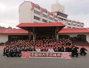 「早稲田大学応援部」の横断幕を持った市長と学生、関係者が集合し、記念撮影する写真