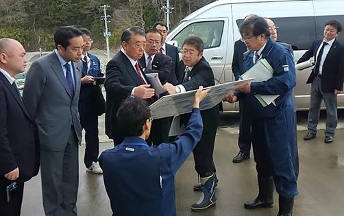 大島理森自民党震災復興加速化本部長に市長が、職員が持っている地図を指さしながら 復興状況を説明し、同行している方々もそれを見ている写真