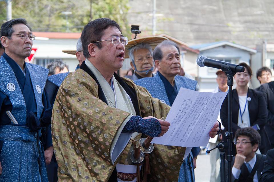 市長や参加者の方々が着物を着て、市長が宮古港開港のセレモニーのあいさつを読み上げている写真