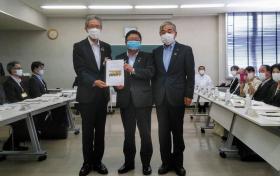 要望書を一緒に持つ市長と男性、その隣に並ぶ男性の記念写真