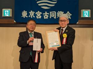 胸章をつけた市長と品川区副区長の和氣正典さんがそれぞれ金封と感謝状を手に持ち記念撮影している写真