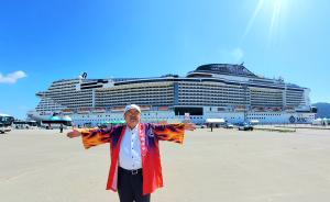 外国客船「MSCベリッシマ」の前で赤や黄色の半被に鉢巻をした市長が両手を広げ記念撮影している写真