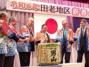 日本酒の大きな樽を鏡開きする様子の、法被を着た市長と5名の男性の写真
